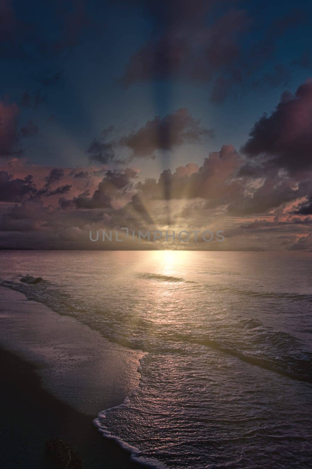 Sunset, illuminated sea. Sandy beach in the foreground. Light waves. Baltic Sea. Landscape on the coast