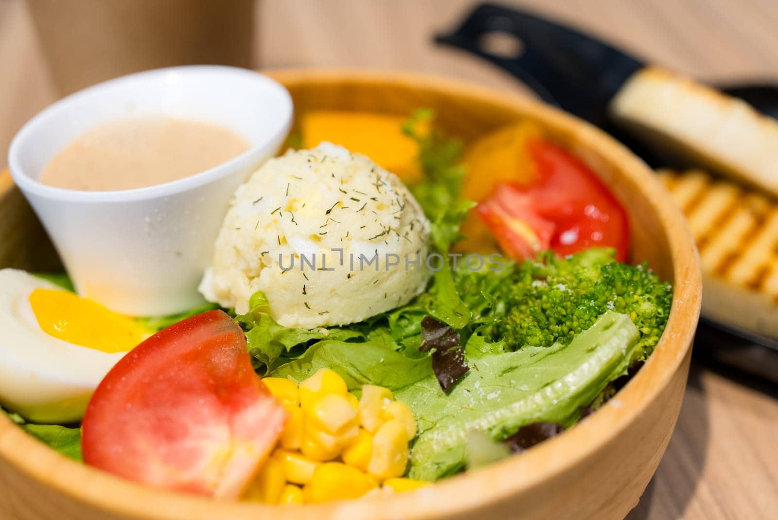 Fresh salad in the wooden bowl