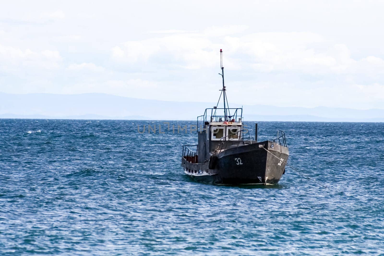 Fishermen in a motor boat sailing on Lake Baikal. Fishermen in a motor boat sailing on Lake Baikal.