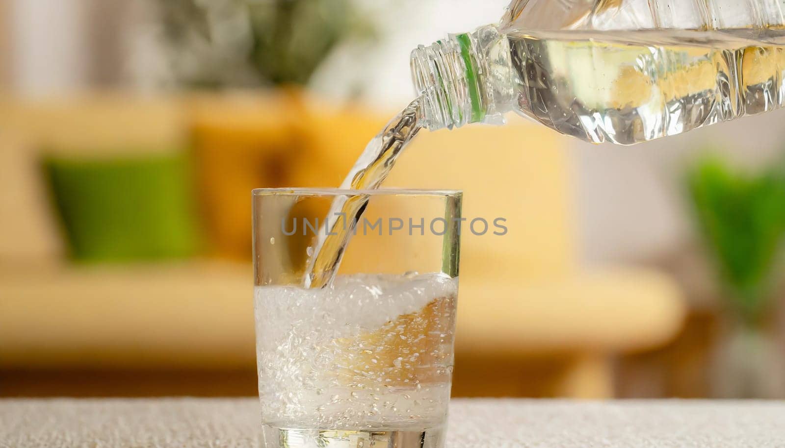 Close up the pouring purified fresh drink water from the bottle on table in living room
