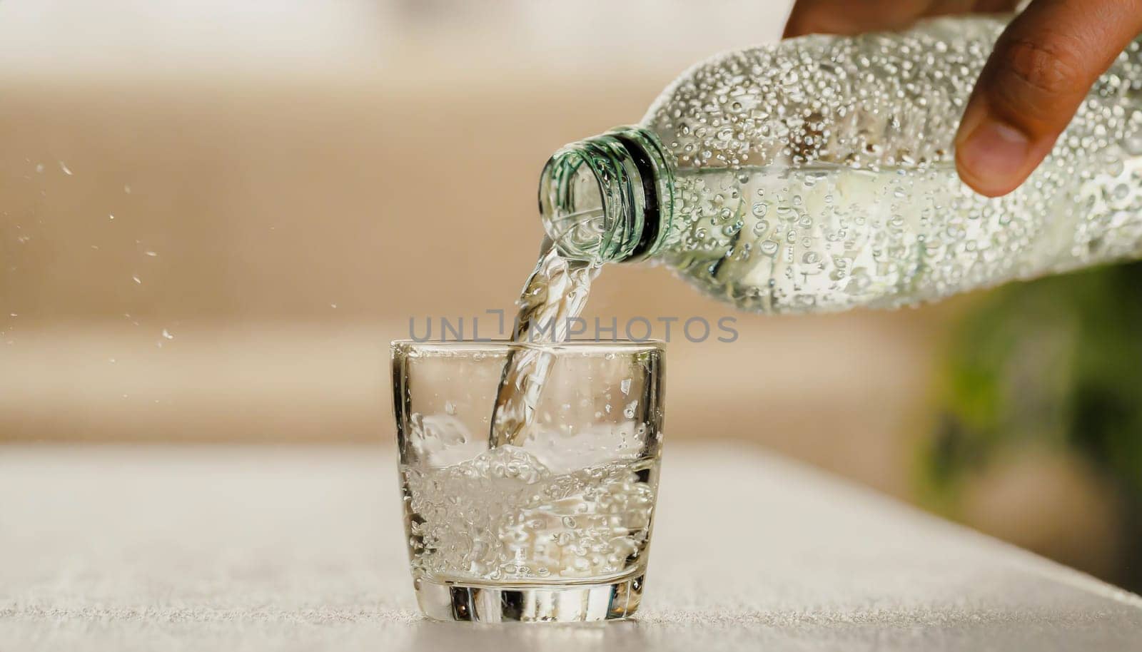 Close up the pouring purified fresh drink water from the bottle on table in living room