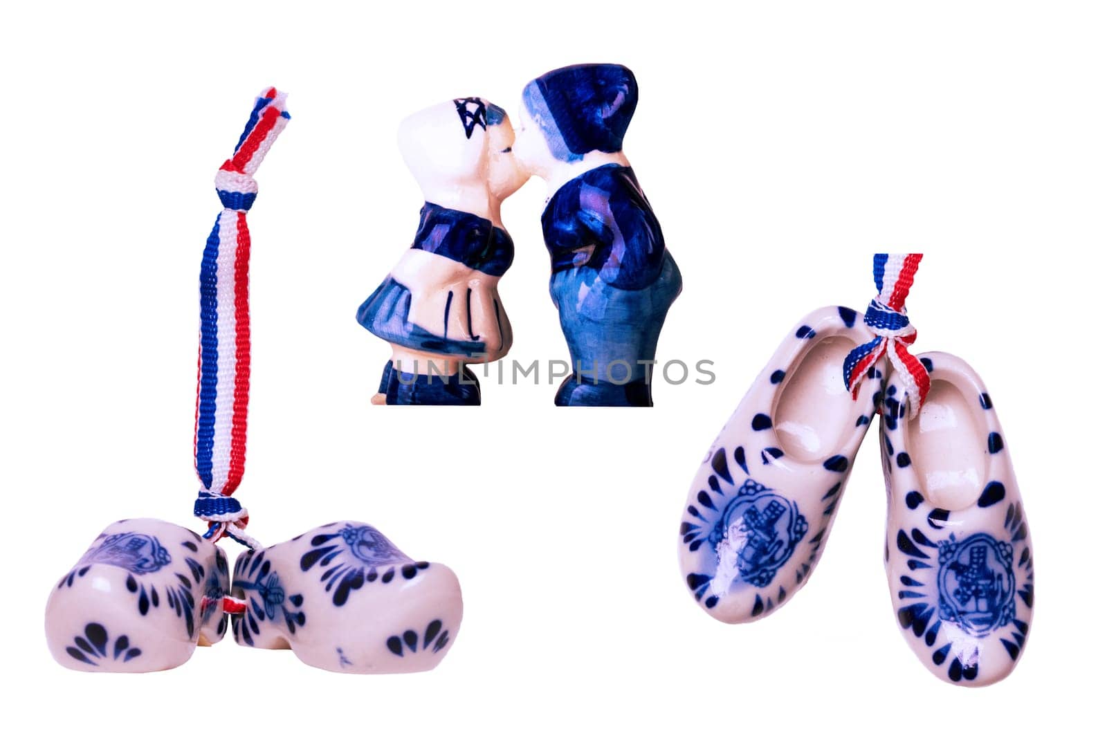 Traditional dutch porcelain shoes with a ribbon flag and kissing boy and a girl in traditional Dutch costumes isolated. Holland wooden clogs. Souvenir from Amsterdam.