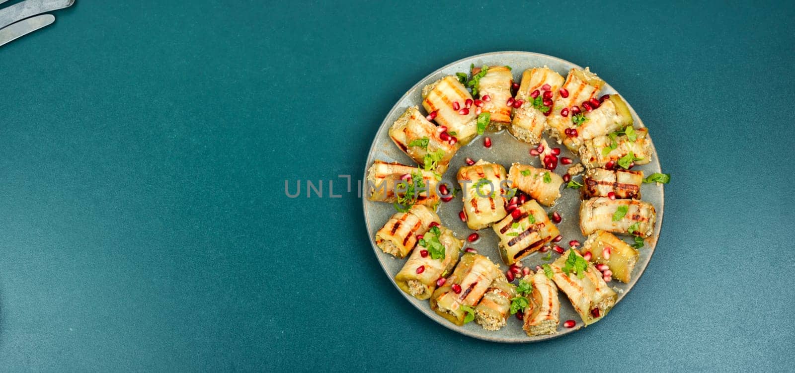 Fried eggplant rolls with walnut, garlic filling and decorated with pomegranate. Badrijani