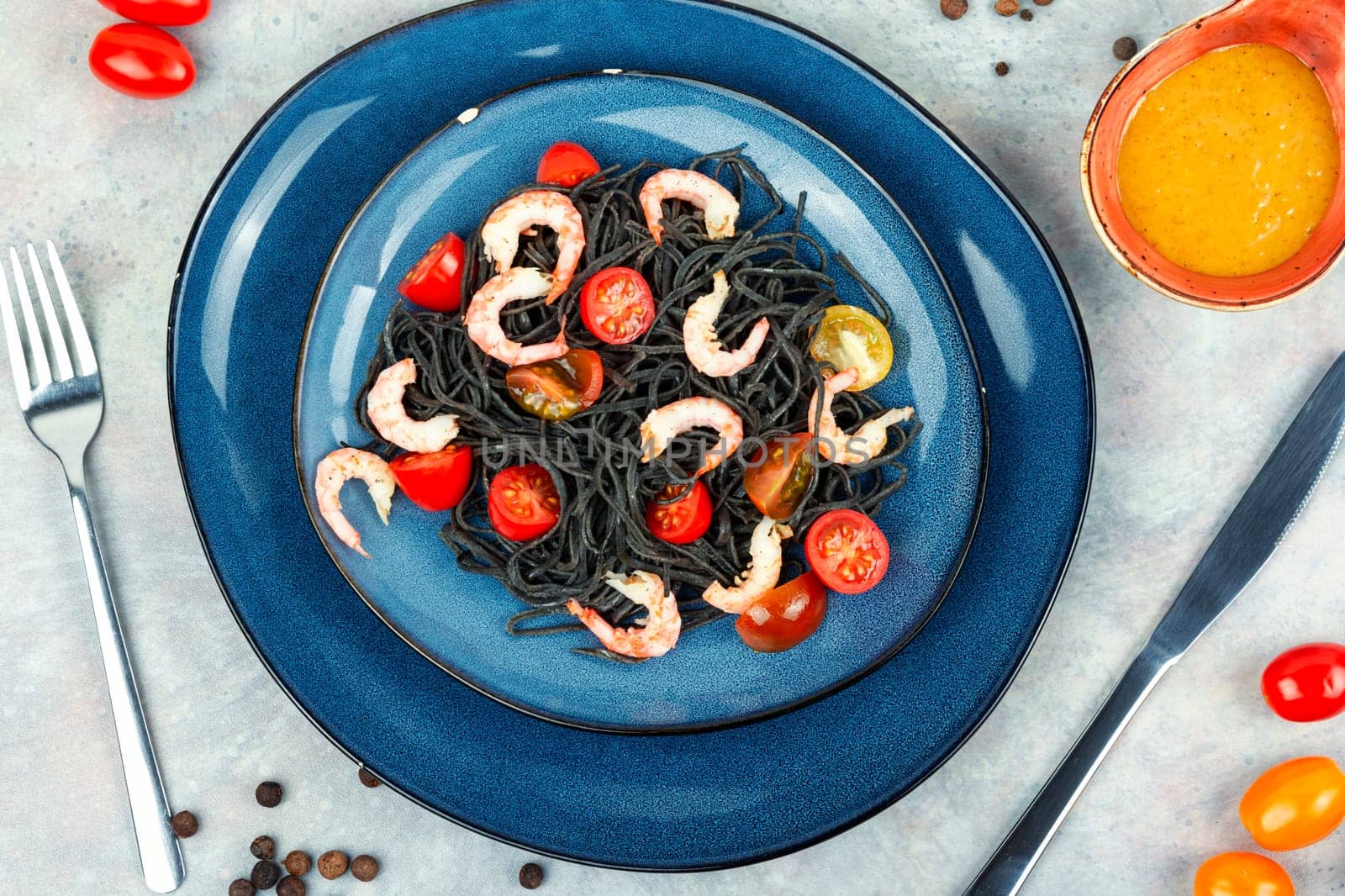 Vegan black bean spaghetti with shrimp and tomatoes.