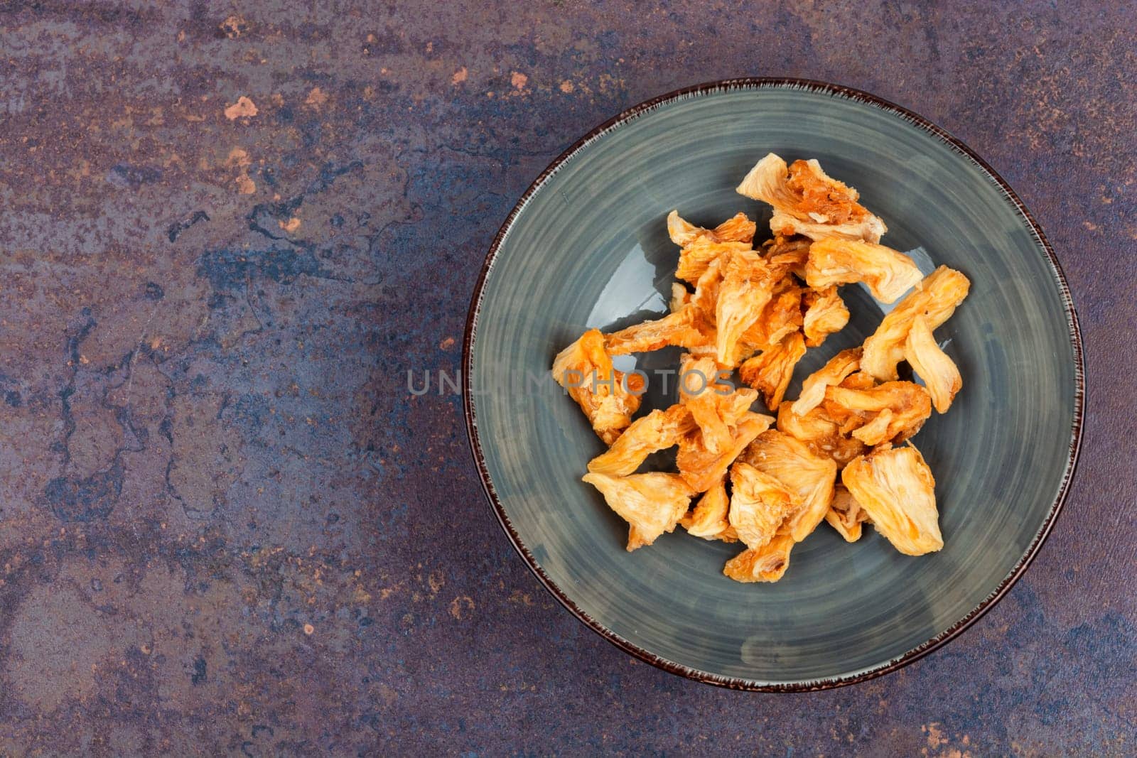 Dried tasty pineapples or ananas in bowls. Candy pineapples.
