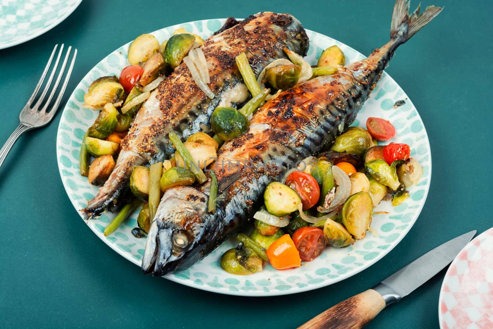 Plate with roasted mackerel or scomber fish and tomatoes, cabbage and green beans