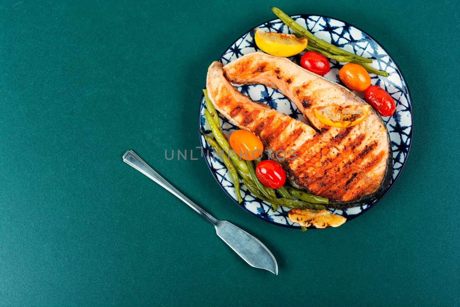 Grilled salmon steak with grilled vegetables, fried fish. Space for text.