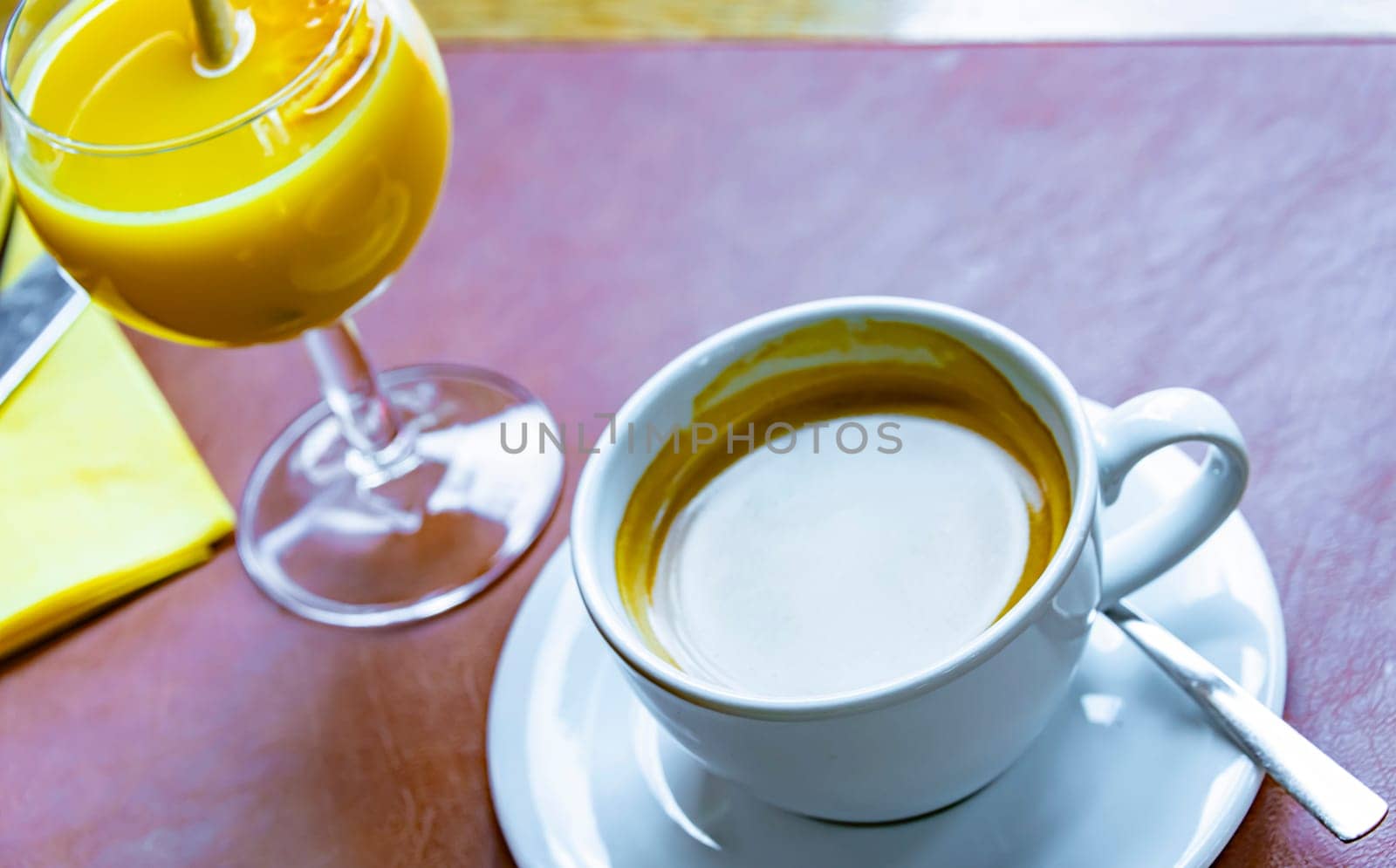 A cup of coffee and orange juice on the restaurant table