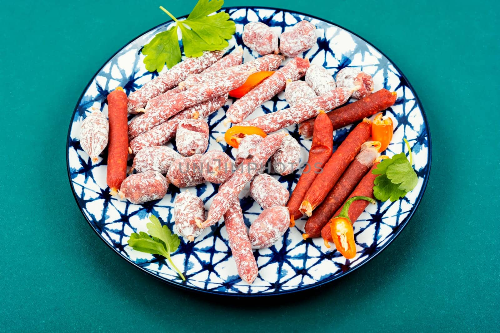 Three varieties of salami sausage on a plate, meat appetizer. Top view.