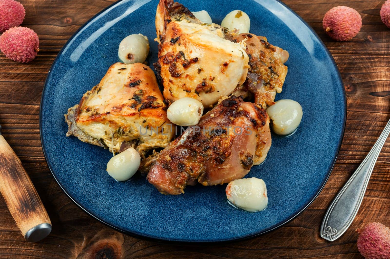 Pieces of grilled or smoked chicken meat with lychee on a plate.