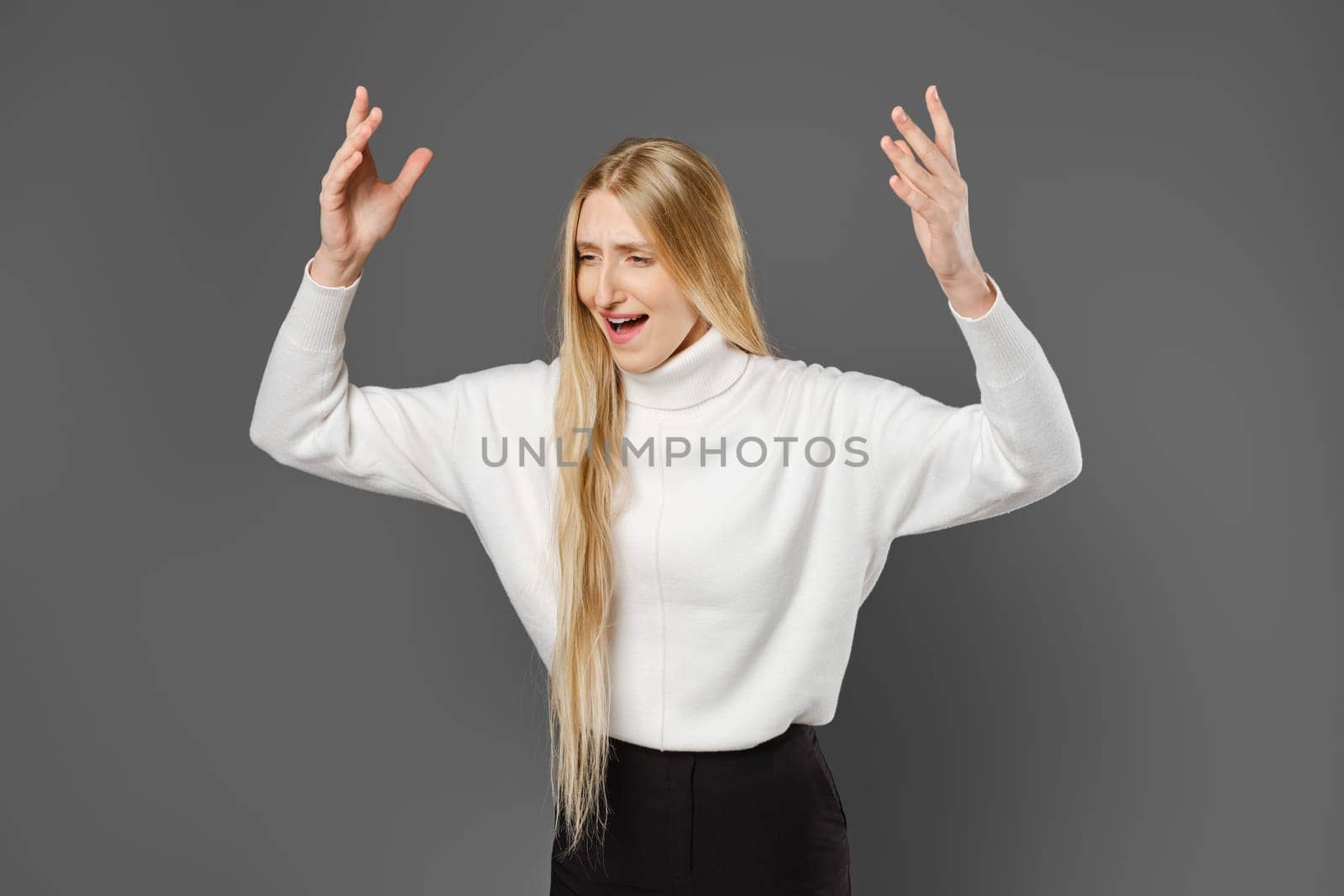Dissatisfied young woman swears and gesticulates emotionally with her hands