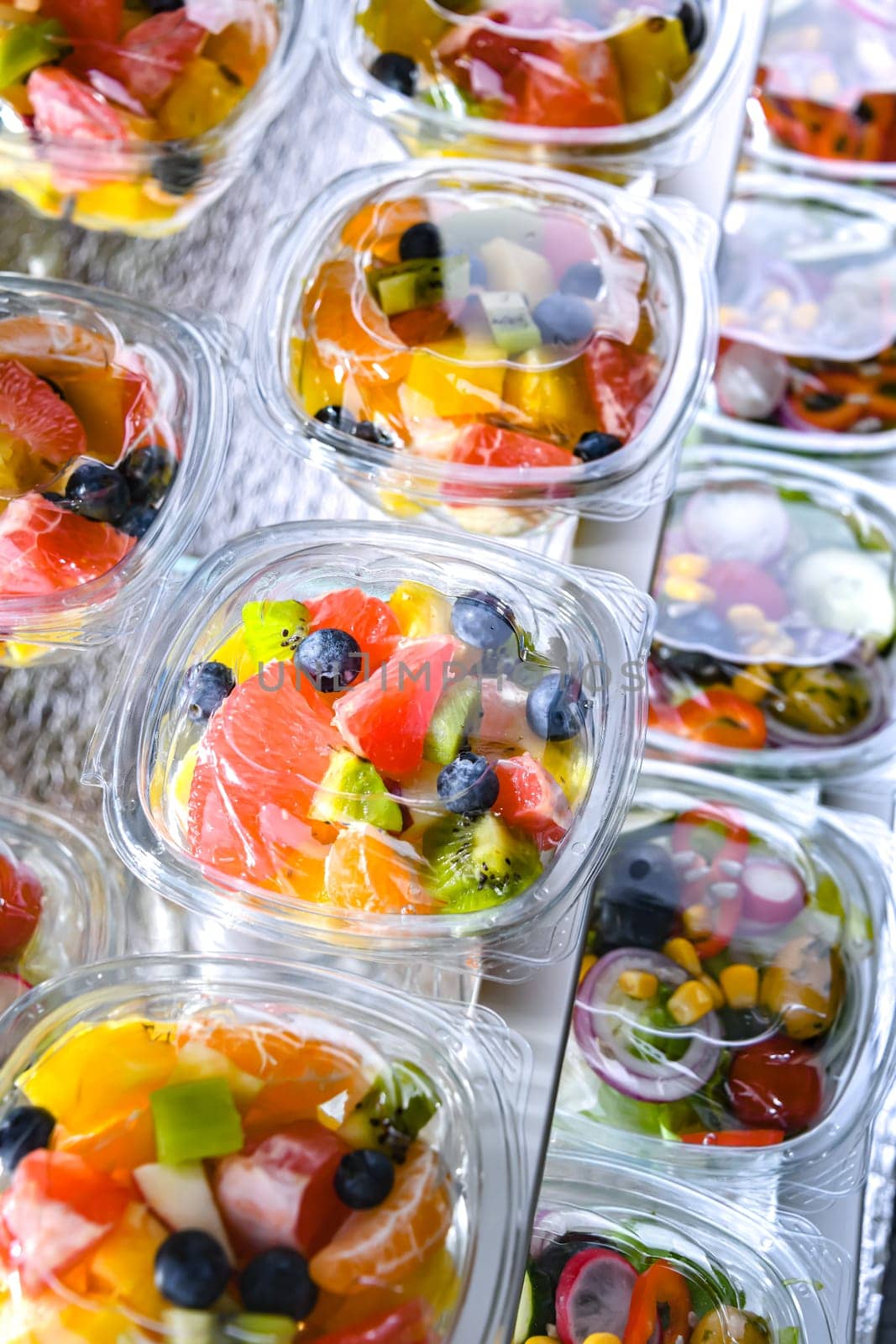 Plastic boxes with pre-packaged fruit salads, put up for sale in a commercial refrigerator