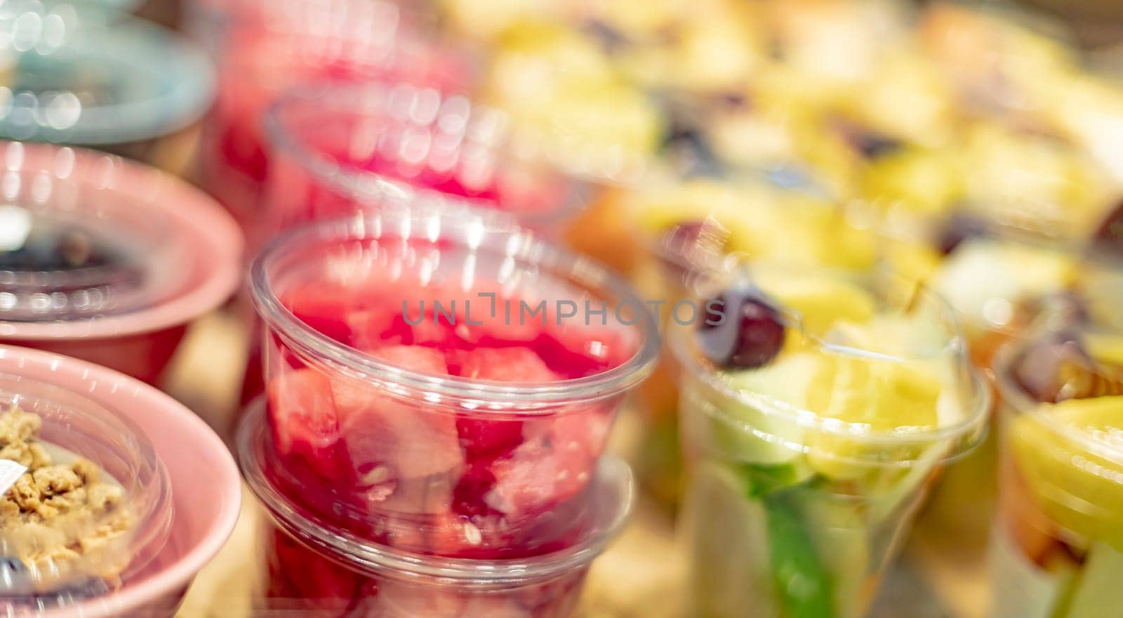 Pre-packaged fruit salads displayed in a commercial refrigerator
