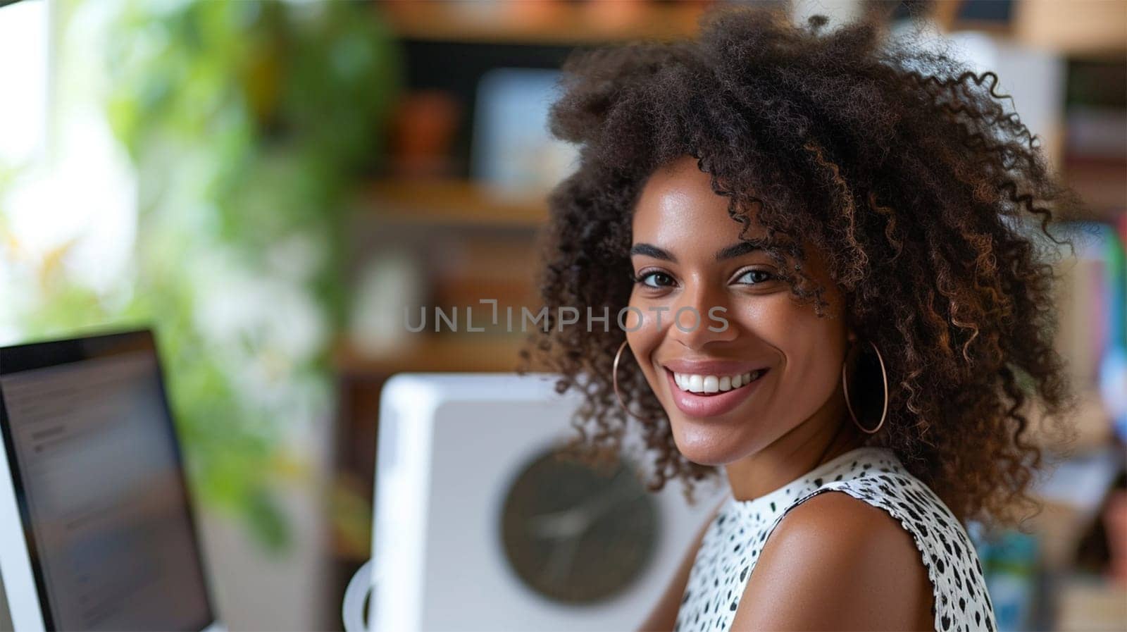 A radiant young professional woman working at her computer in a bright, plant-filled office. Copy space.
