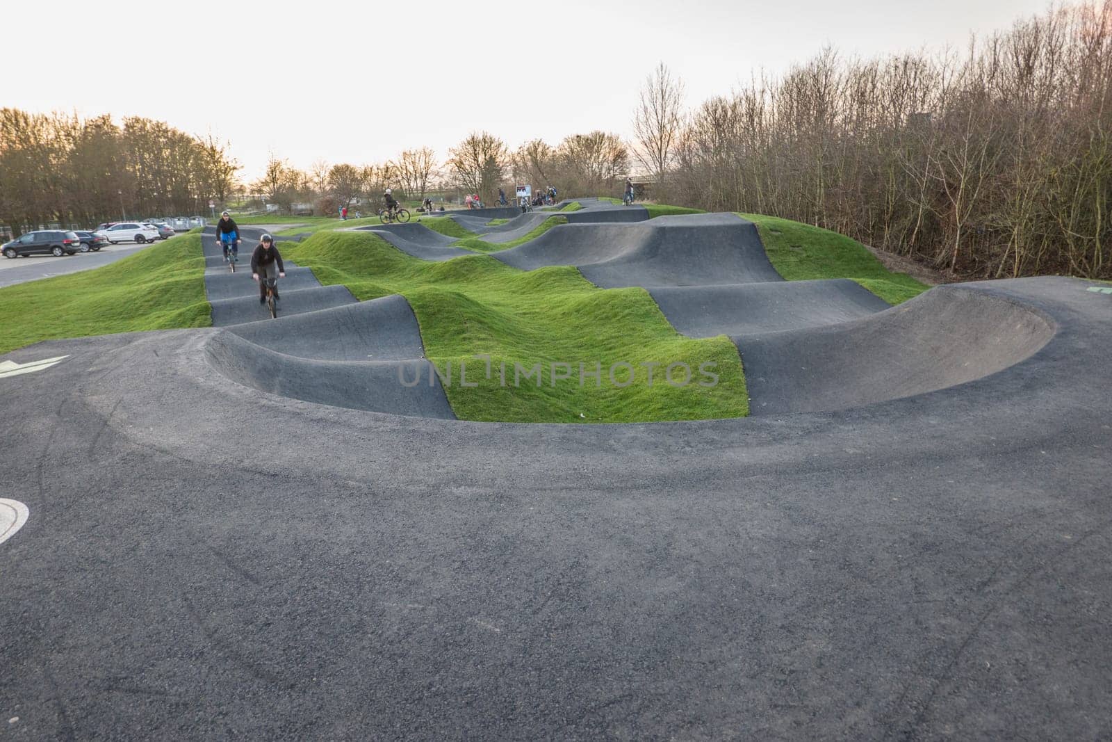 Kinder und Jugendliche fahren mit ihren Fahrrädern über einen asphaltierten pump track, Nordrhein-Westfalen, Deutschland, Weilerswist