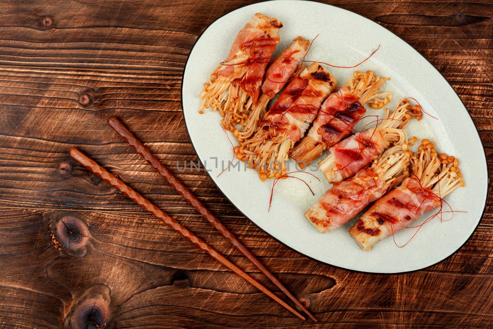 Bacon rolls stuffed with enoki mushroom. Bacon wrapped mushroom. Flat lay with copy space.