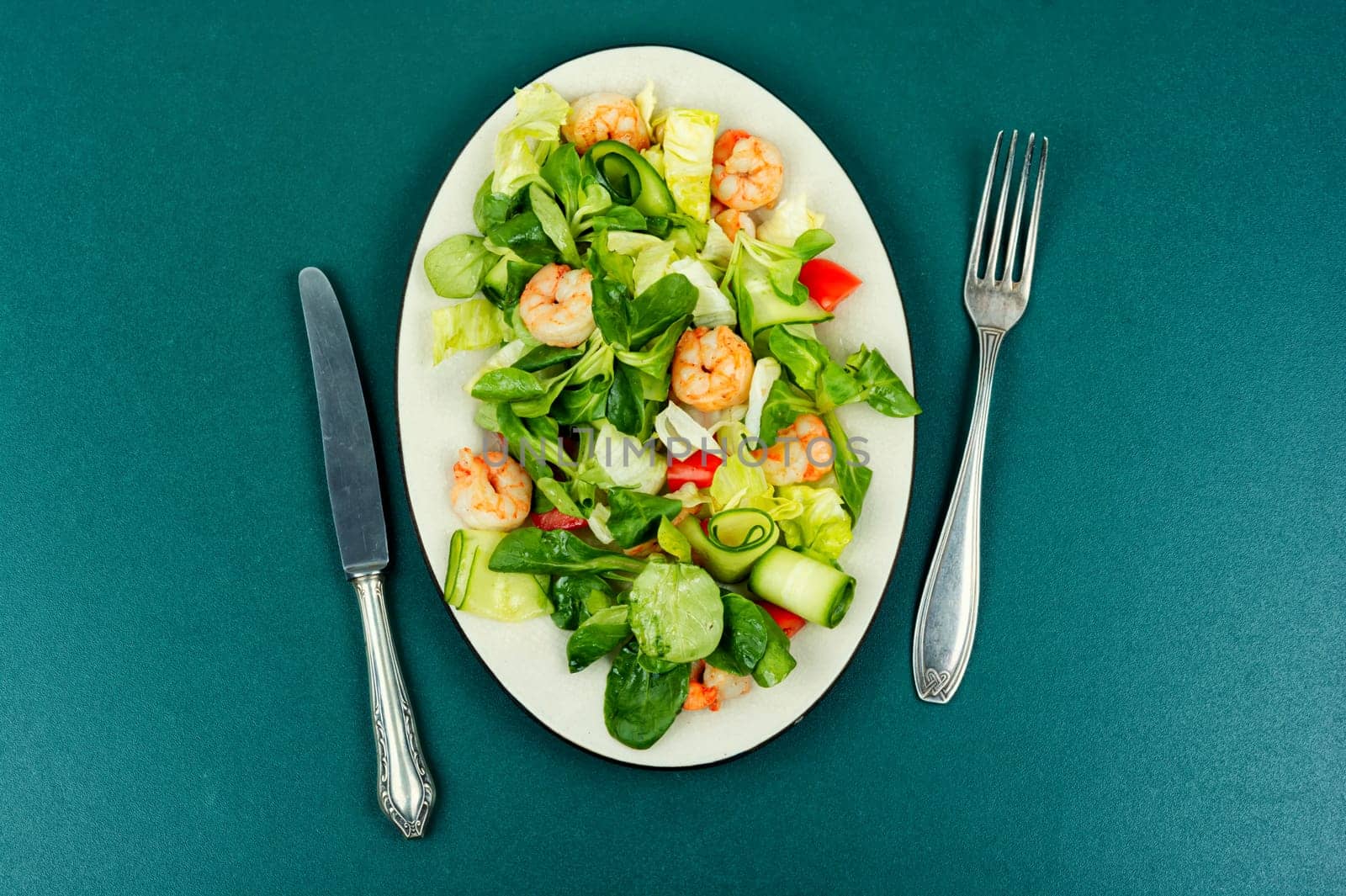 Plate with salad of fresh vegetables, herbs and shrimp. Prawns salad. Top view.