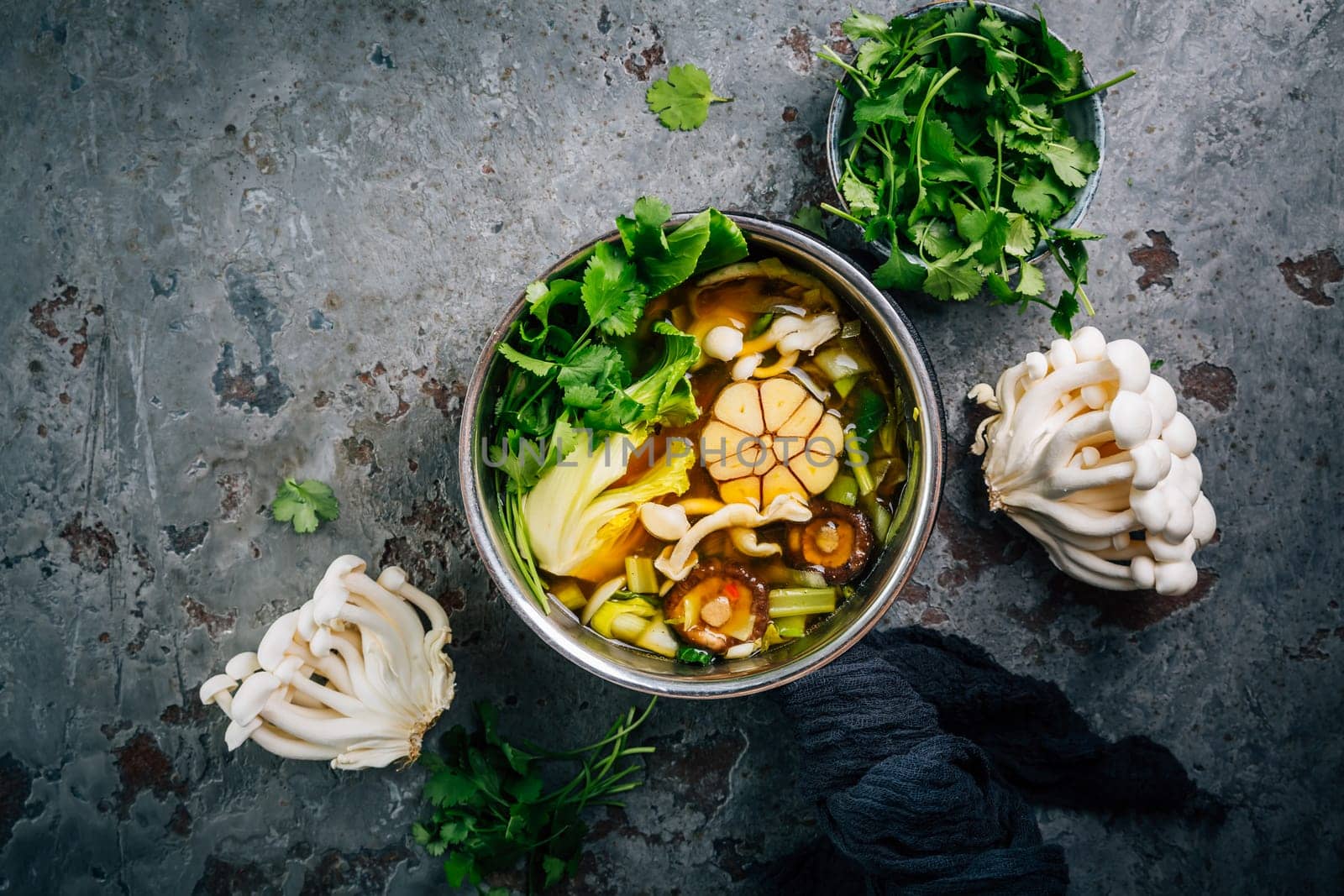 Beef and miso garlic broth, soup with vegetables, mushrooms and cilantro in a pot