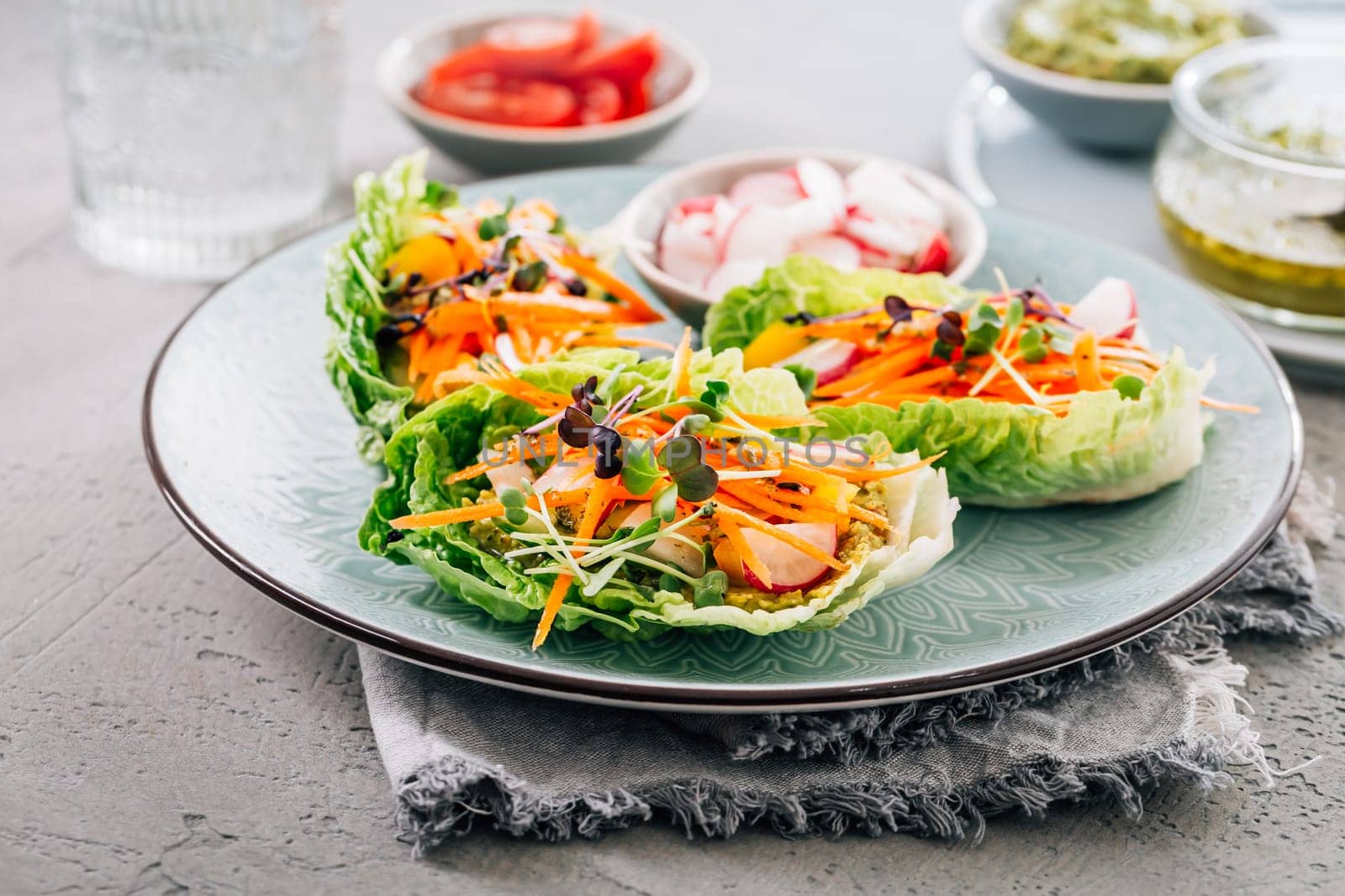 Vegan lettuce wraps with vegetables, avocado spread and microgreens, healthy snack