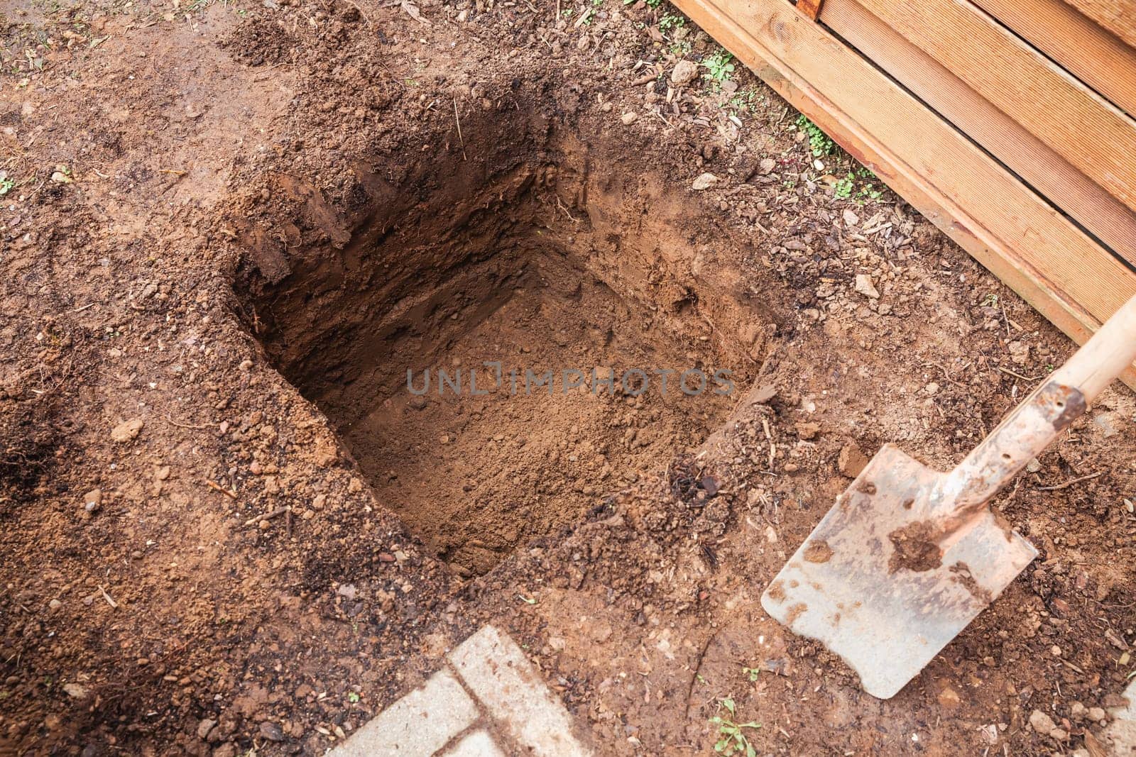 Hole in a soil, prepared for planting or construction, pit in a ground with shovel