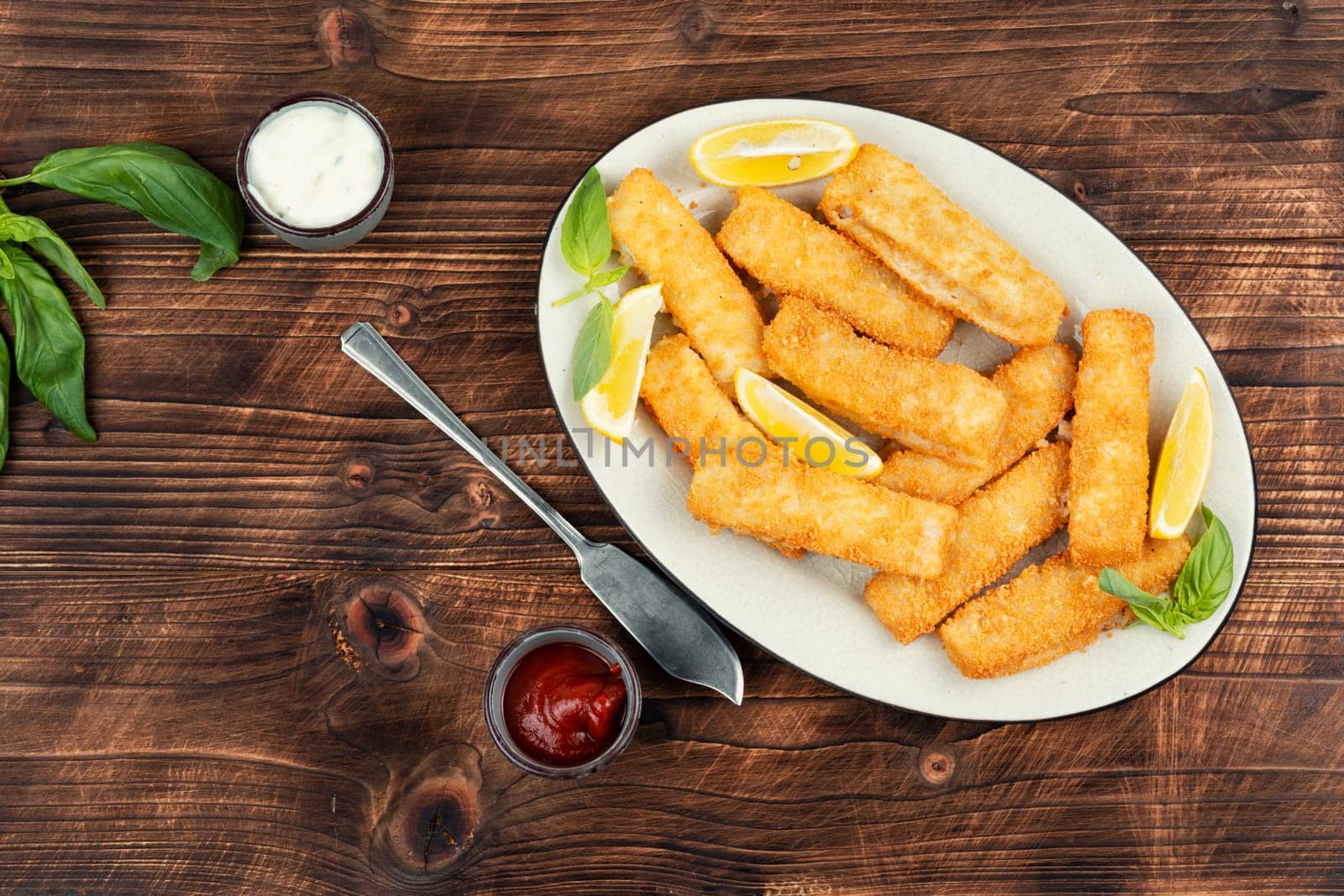 Delicious fish fingers or nuggets, crispy fish steak on the plate.