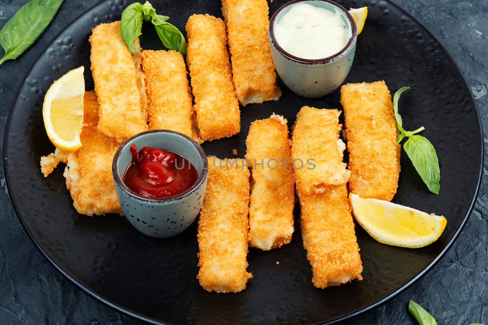 Delicious fish fingers or nuggets, crispy fish steak on the plate.