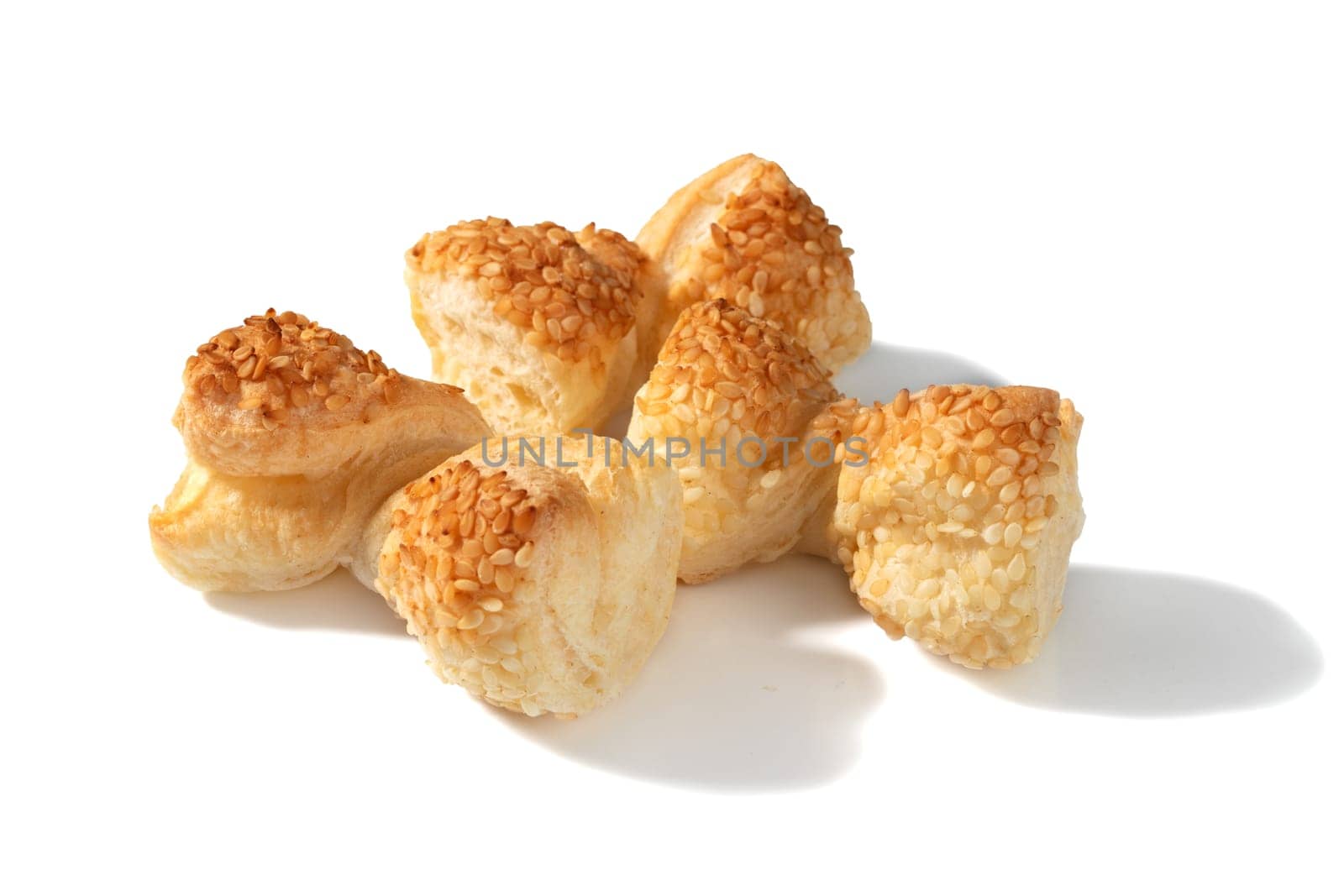 Three golden crackers boast a delightful twist and sprinkle of sesame seeds for a delightful snack experience.