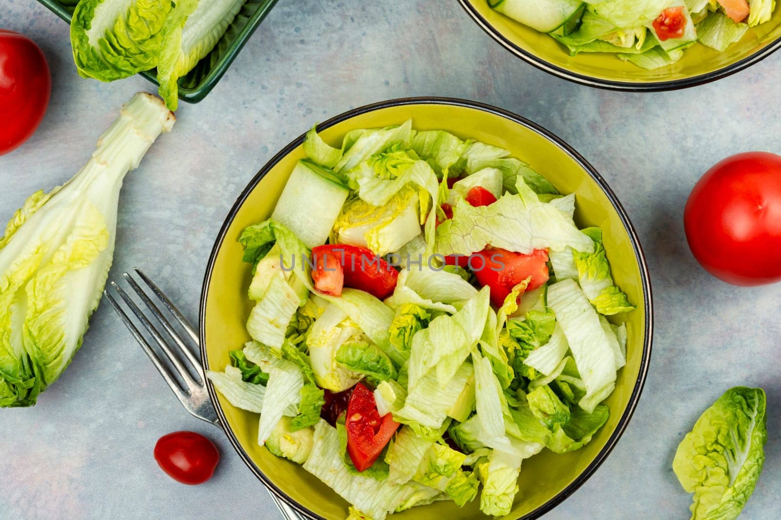Green vegan salad made from a mixture of green leaves and vegetables. Top view.