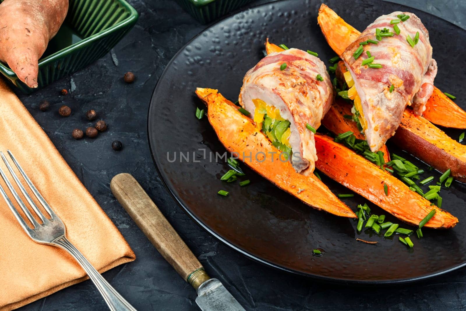 Roasted pork shoulder and sweet potatoes. Roulade with bacon and vegetables. Flat lay.