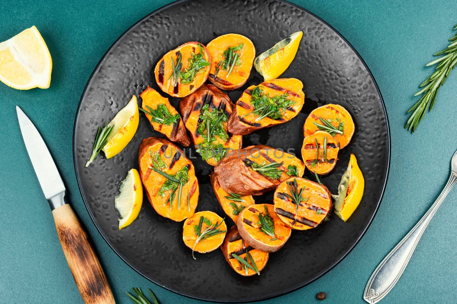 Grilled sweet potato, batata with olive oil and herbs. Copy space.