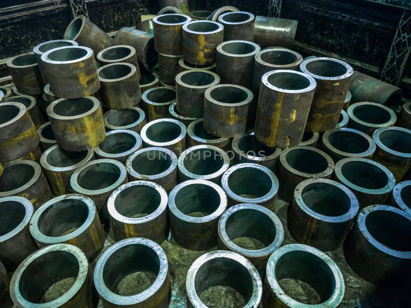 many thick-walled iron pipe chunks sawn on a band saw.