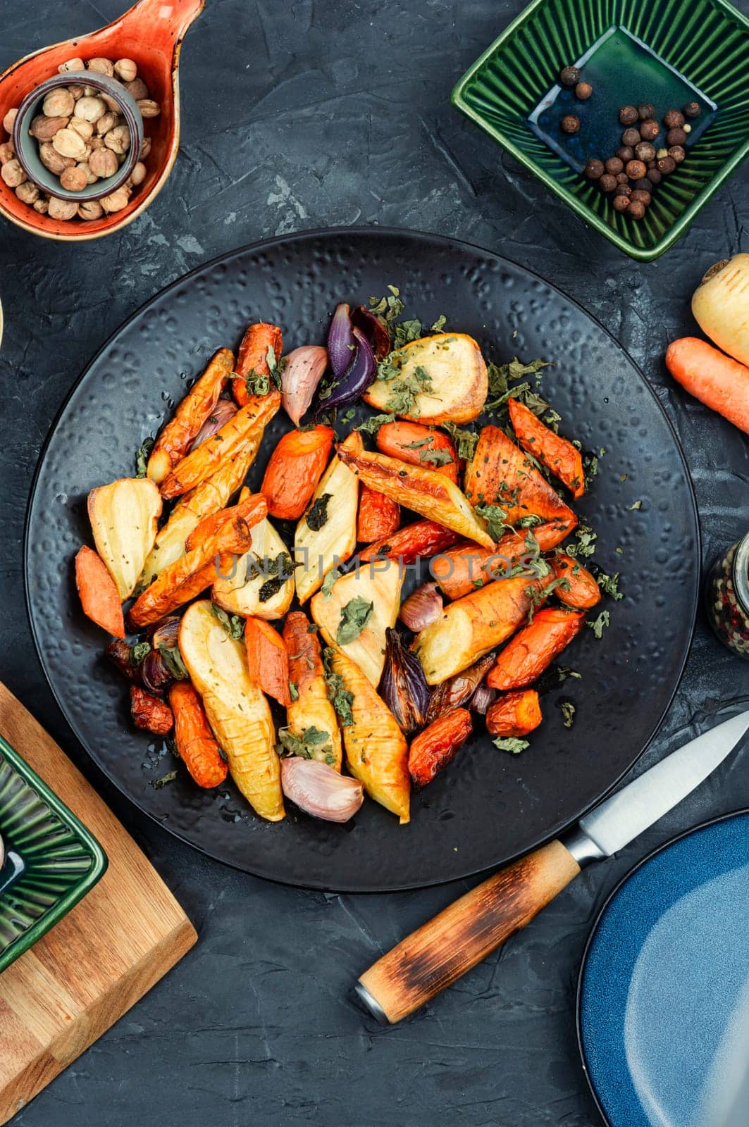 Winter vegan food of baked parsnip root and carrots. Roasted root vegetables.