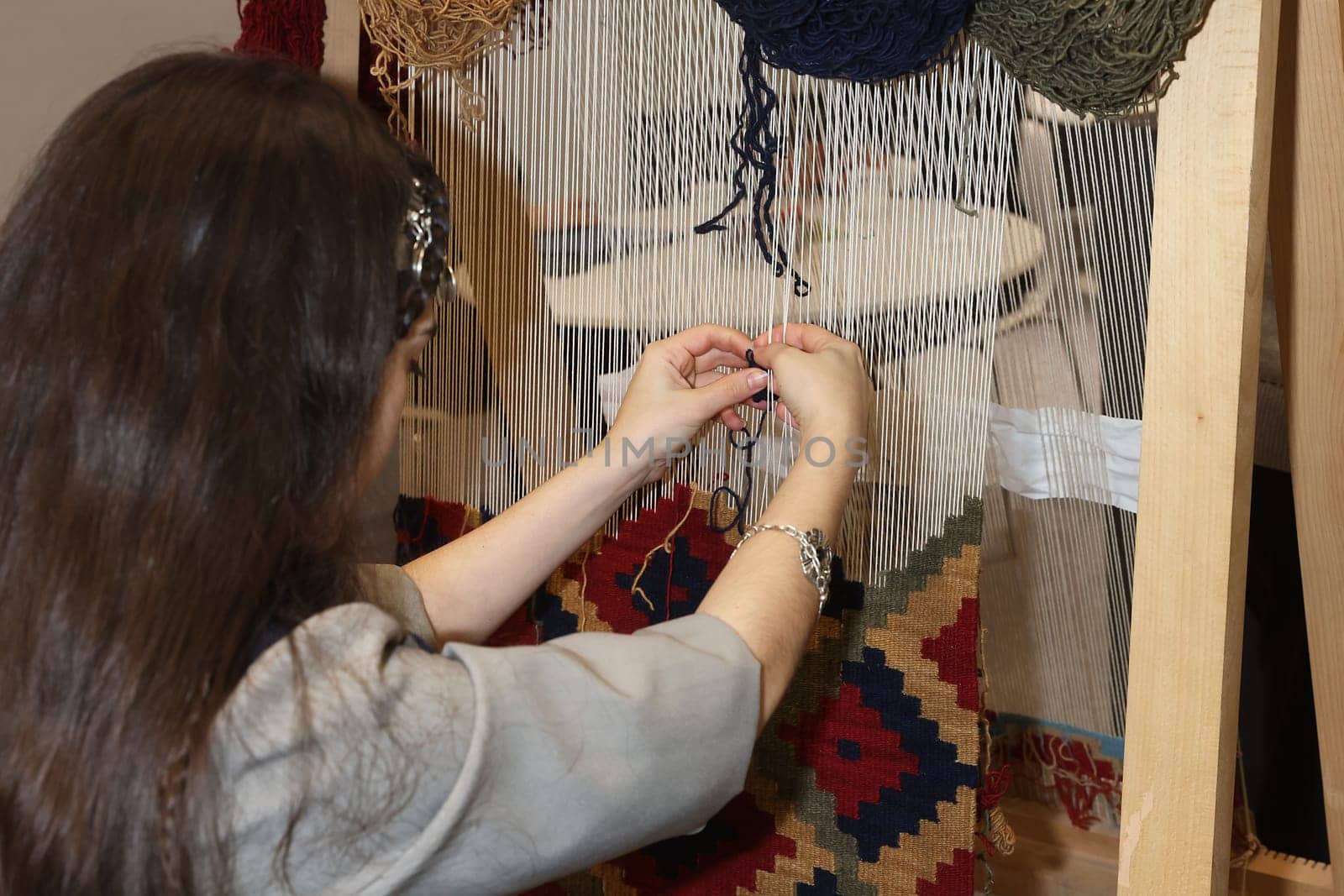 A lady making a rug by hand