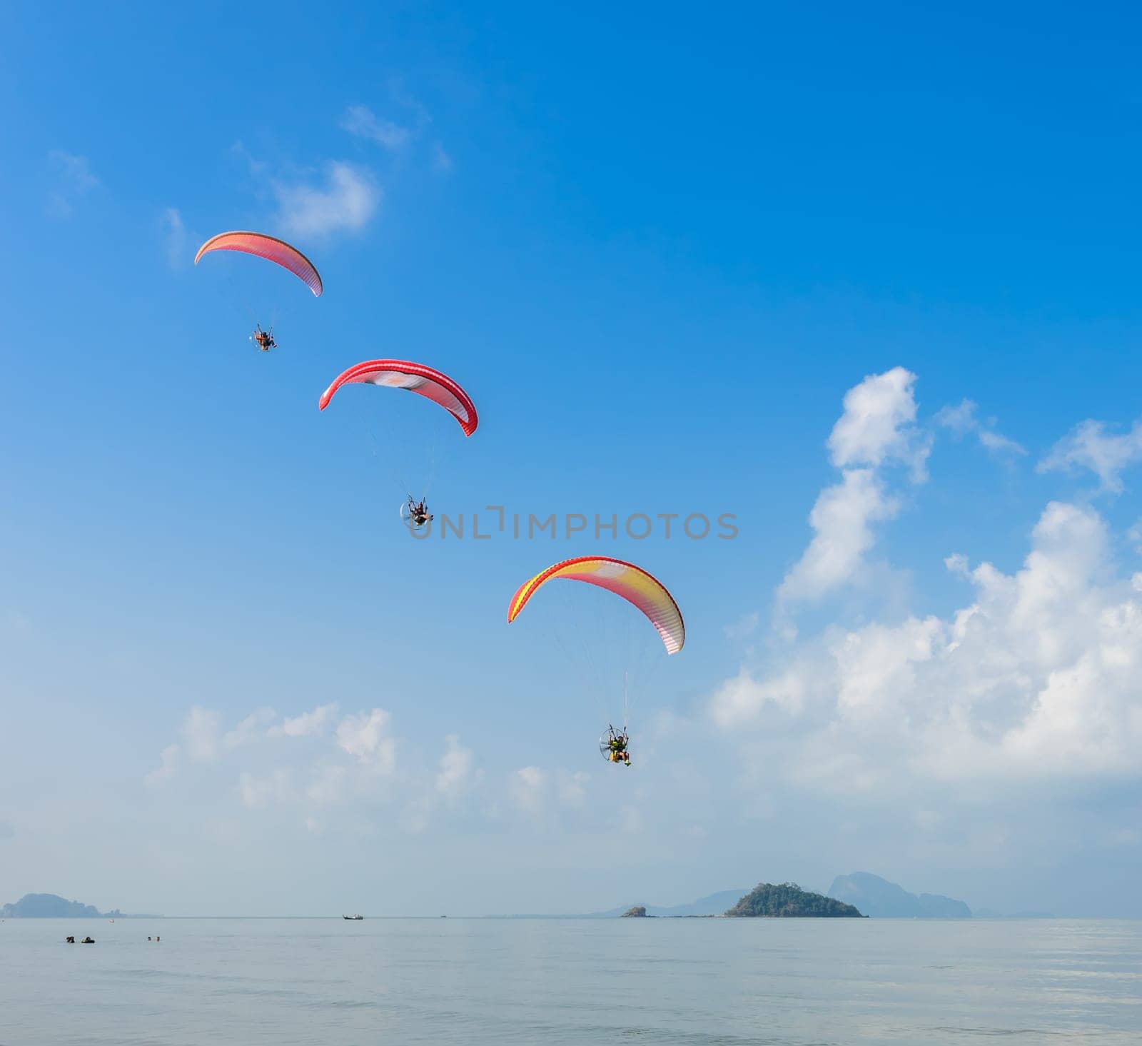 Three Paragliding over Pak Meng Beach in Trang province, Thailand