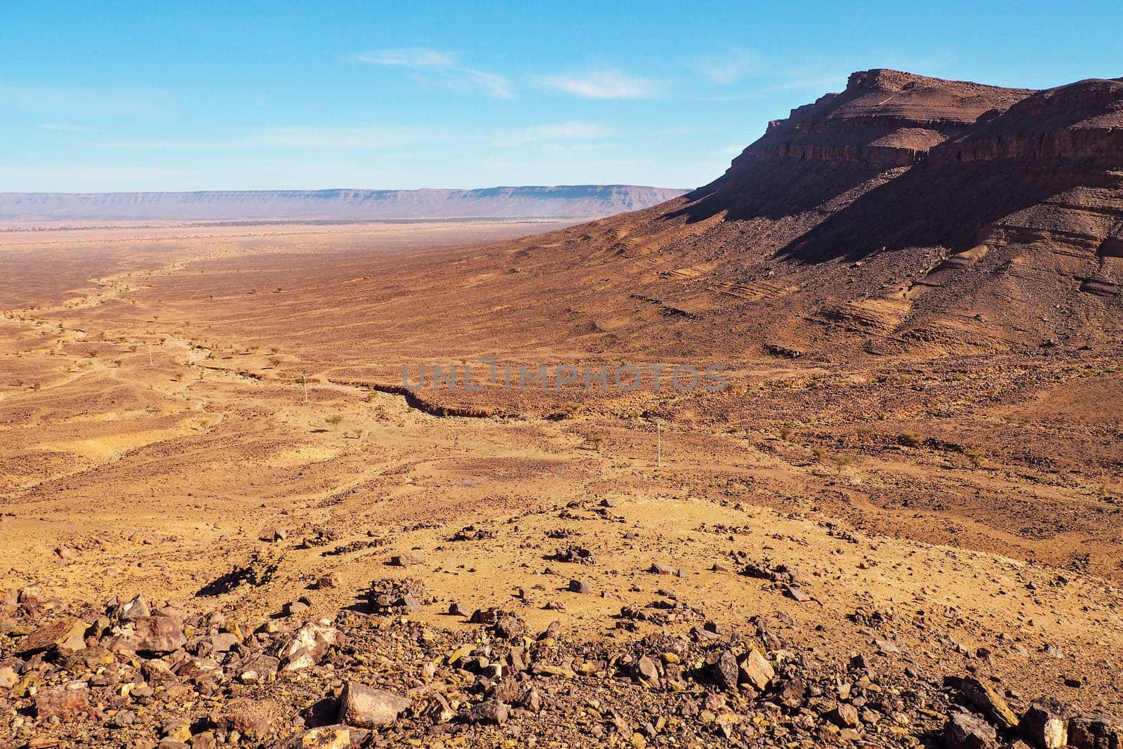 Flat large rocky canyon basin with clear sky above - typical landscape in Southern Morocco