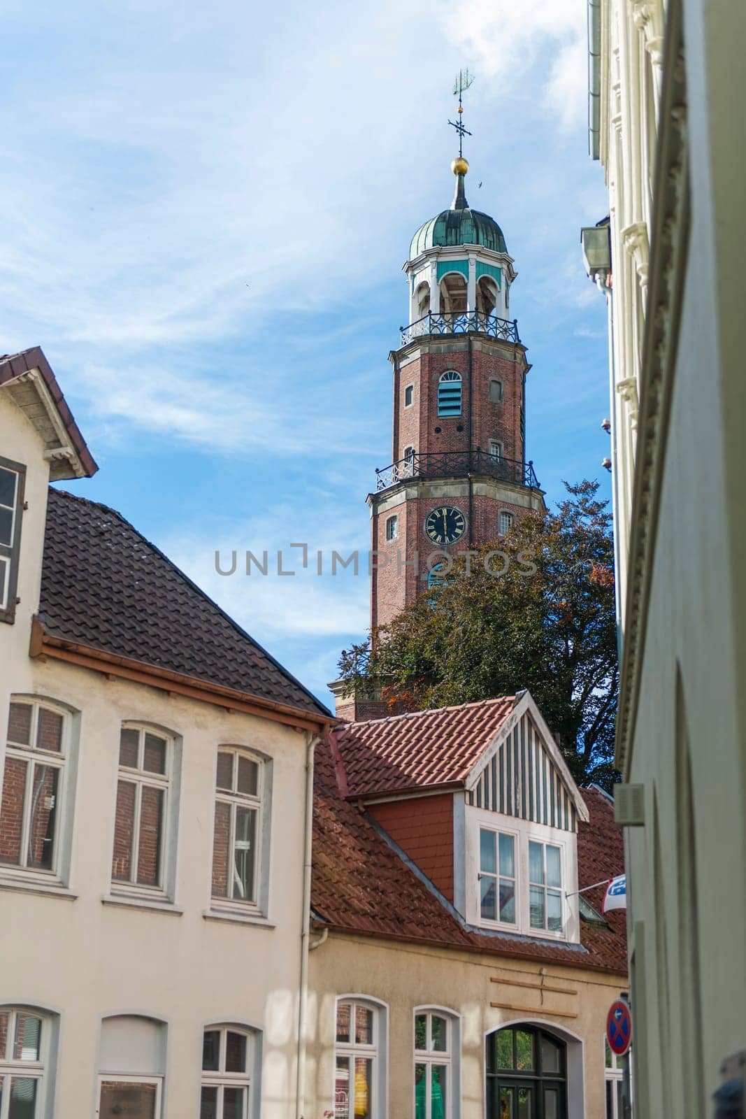 Bell tower of the large Reformed church in East Frisia in autumn 2022 in sunny weather with light veiled clouds.