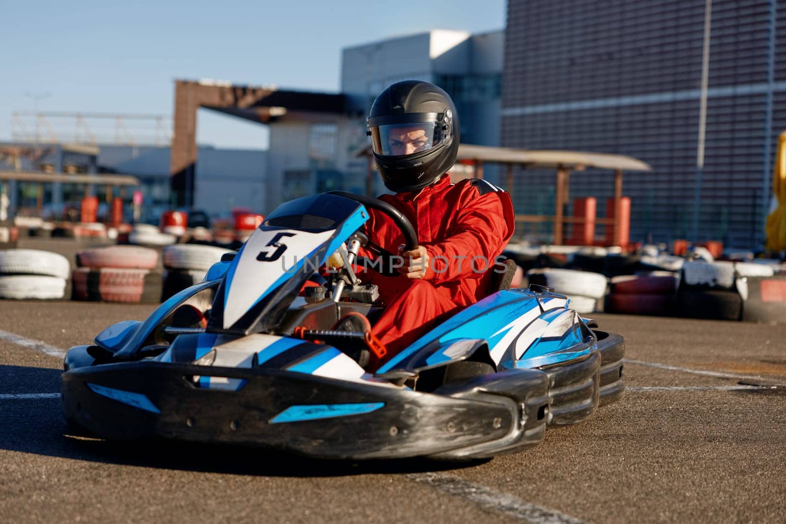 Kart pilot ready to start championship in outdoor go-karting circuit. Tournament entertainment for extreme sports driver