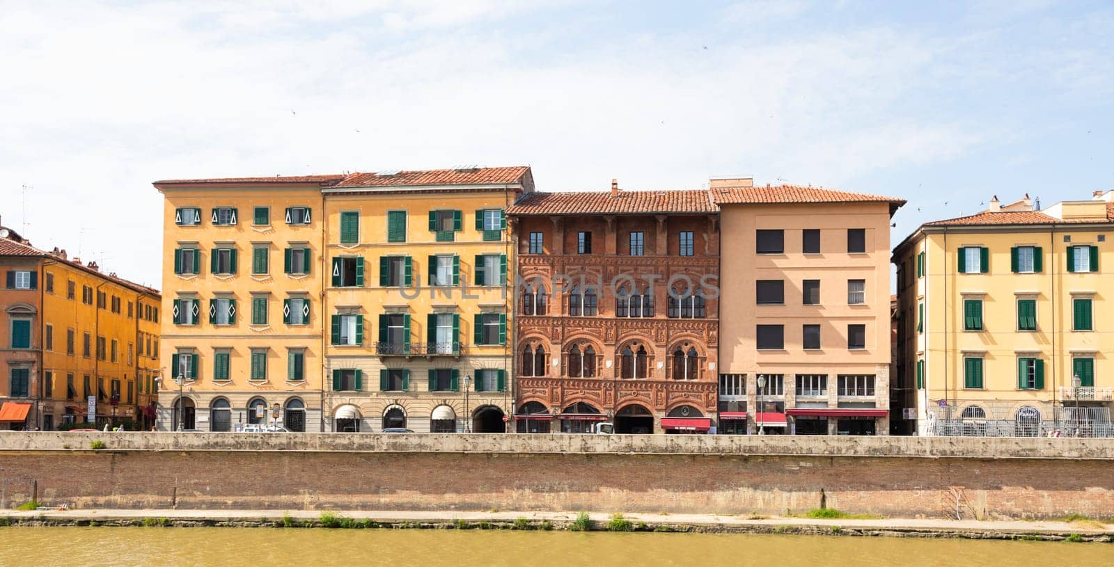 Pisa, Italy - 29 June 2023: colourful buildings on Arno river. Urban skyline, travel destination.