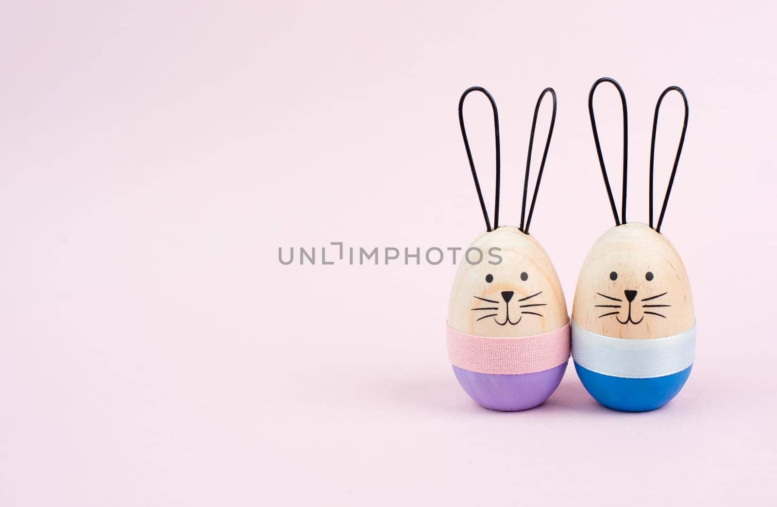 Easter bunny or rabbit couple cuddle together, wooden egg, spring holiday greeting card