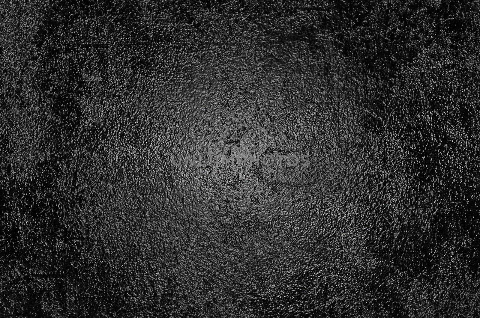 A rough glossy black surface with an illuminated center