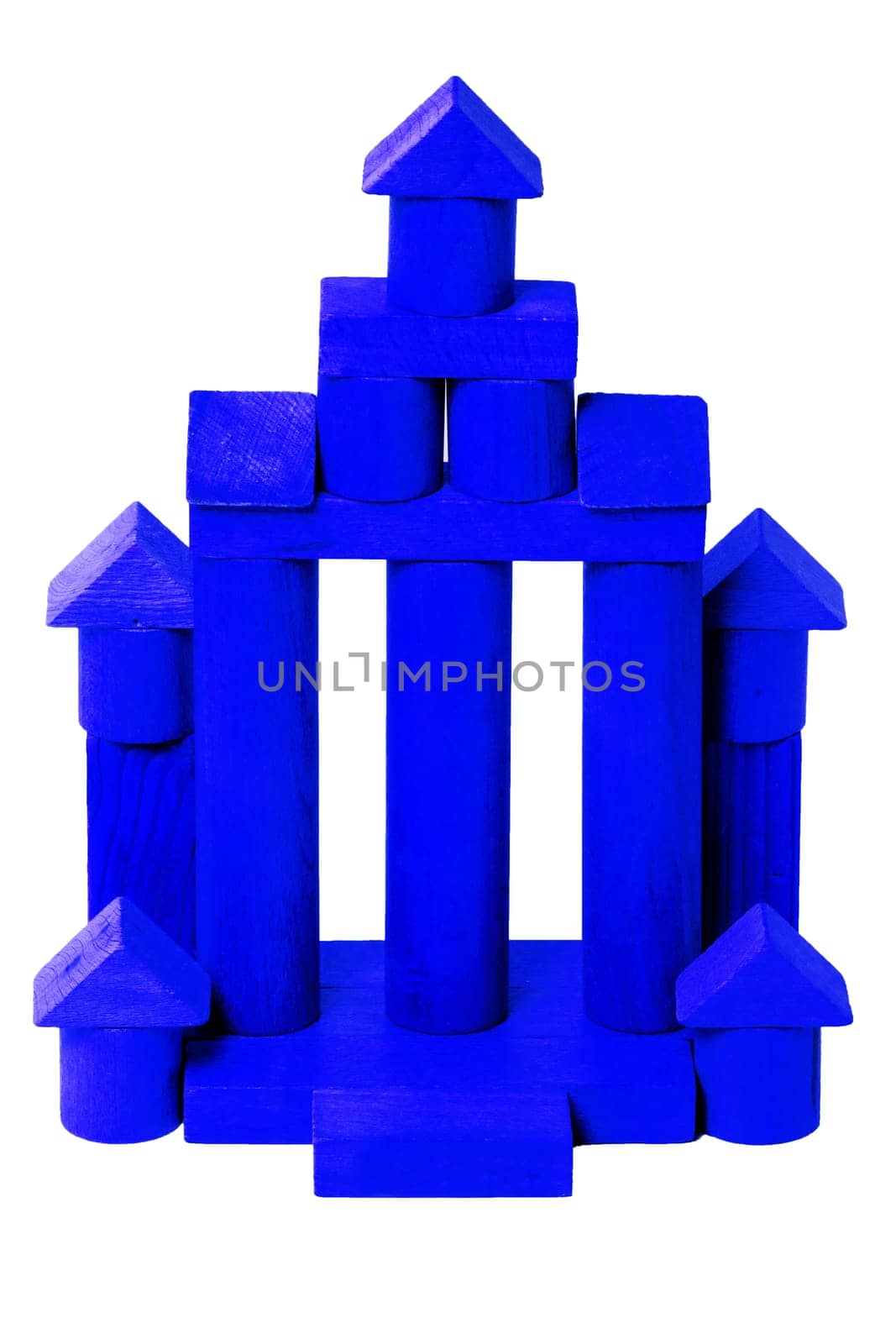 Wooden house isolated. Wooden toy castle constructed of cubes, cylinders, triangles and other shapes. Childrens wooden toy blocks.Macro.