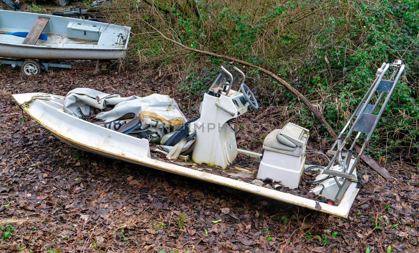 Abandoned motor boat near a forest