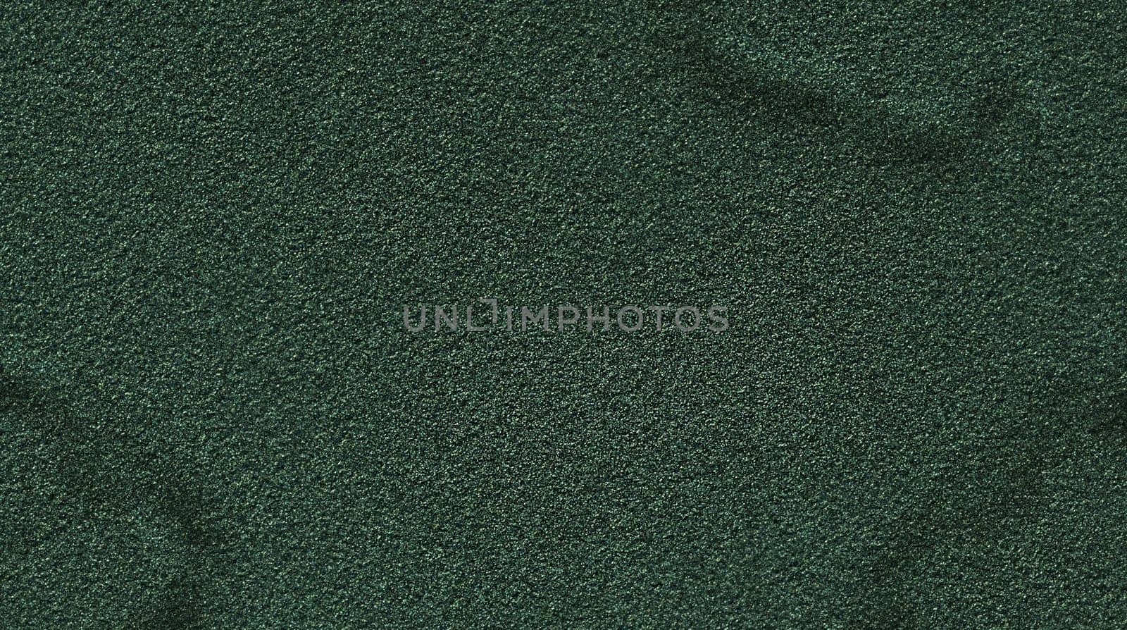 Background texture of a green rough relief mottled surface of dark green color close-up view from above