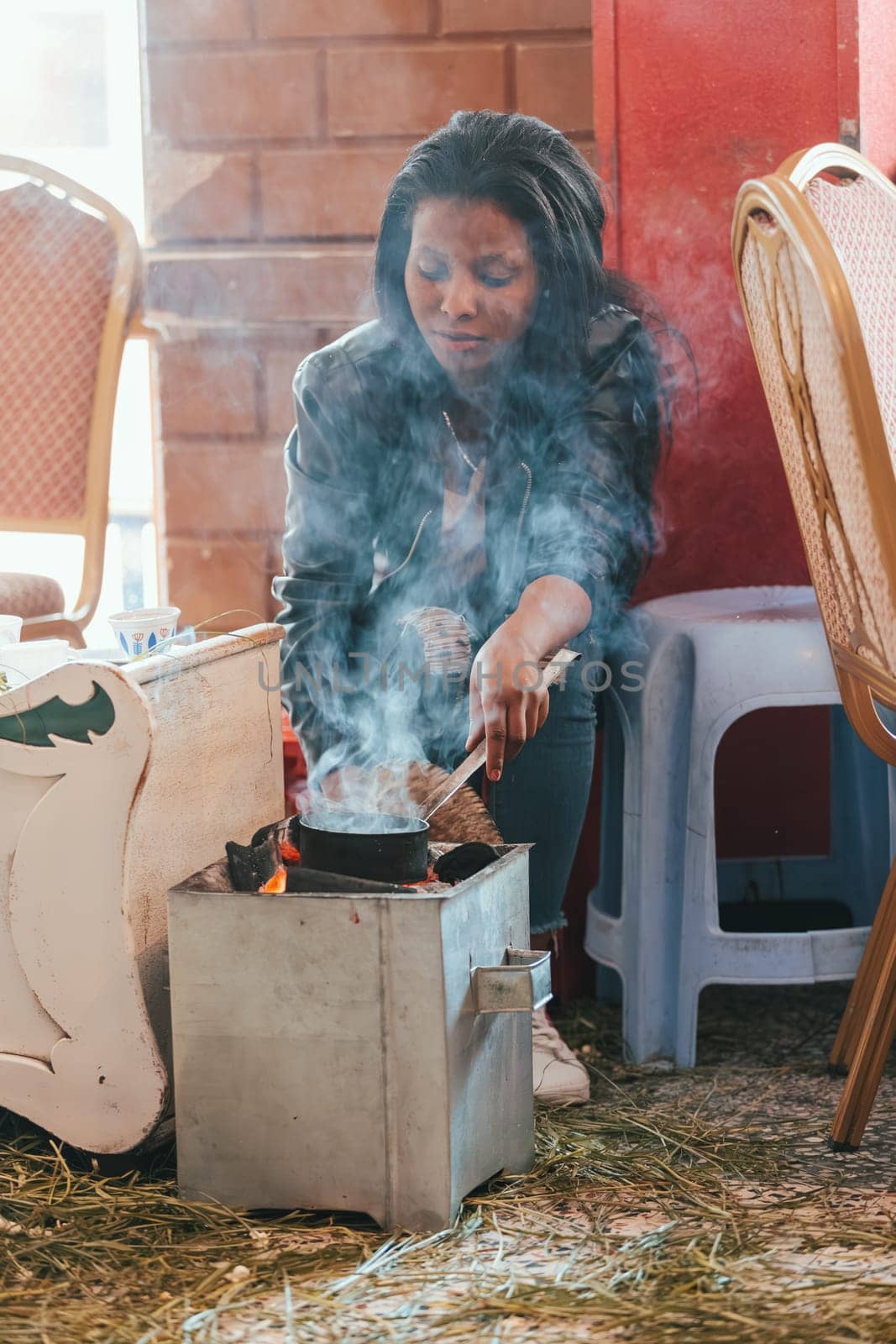 Adigrat Mazegaja Bet, Ethiopia - April 27, 2019: Woman perform a traditional Ethiopian coffee ceremony, preparing street bunna coffee.