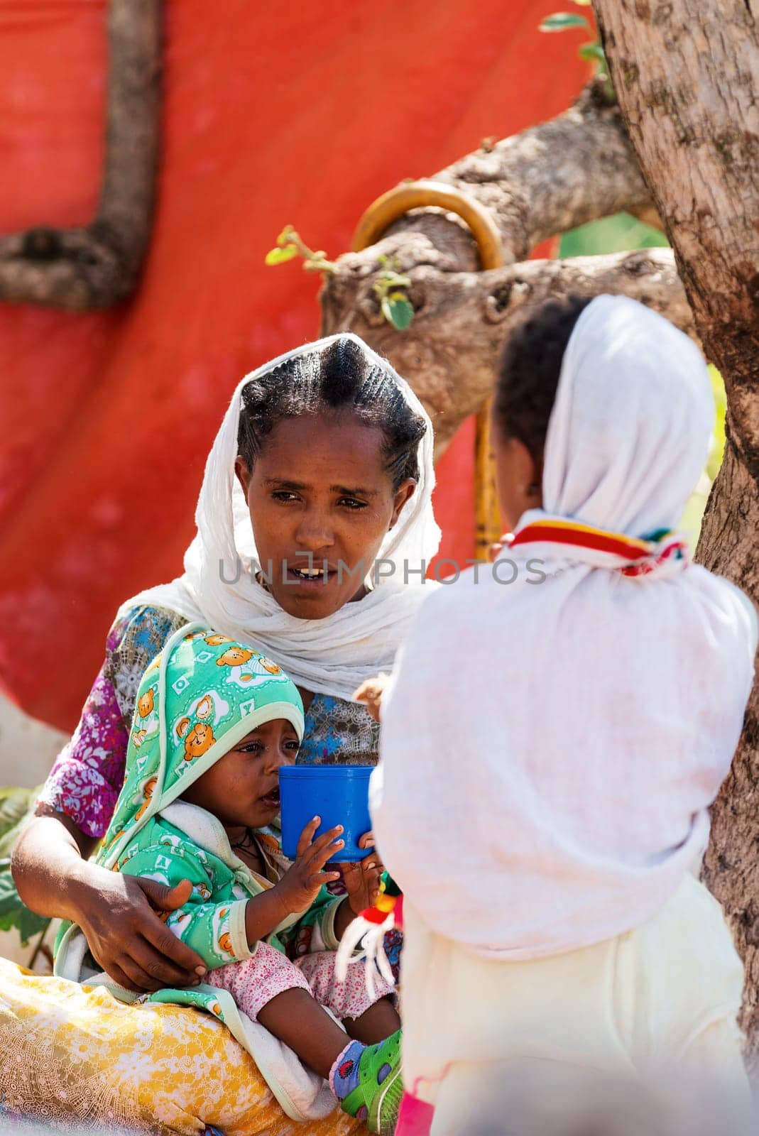 Lalibela, Ethiopia - May 1, 2019: Orthodox Ethiopians unwind at St. George Church after Mass. A serene moment capturing faith and cultural richness.