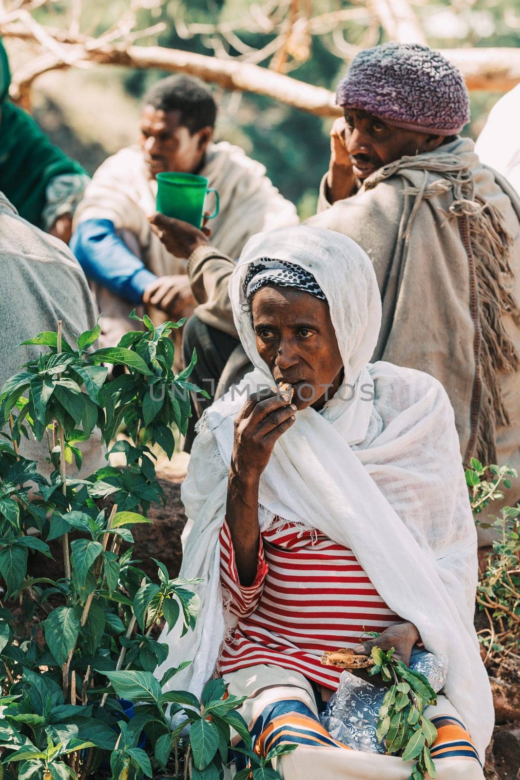 Lalibela, Ethiopia - May 1, 2019: Orthodox Ethiopians unwind at St. George Church after Mass. A serene moment capturing faith and cultural richness.