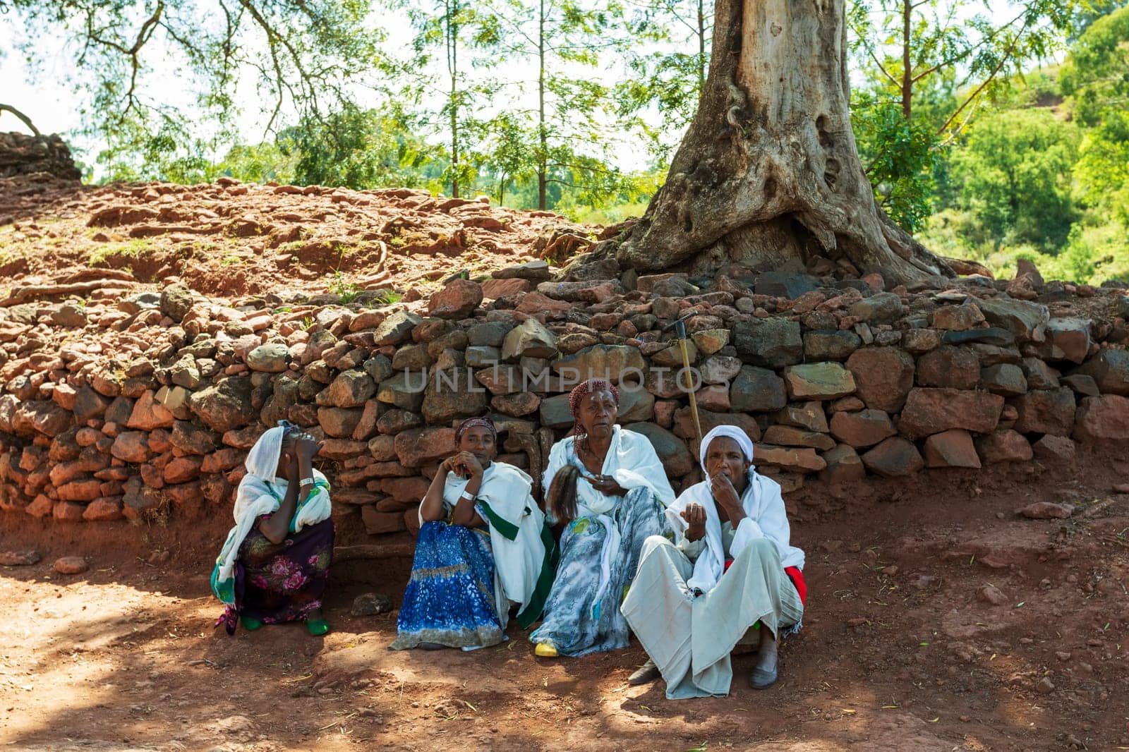 Lalibela, Ethiopia - May 1, 2019: Orthodox Ethiopians unwind at St. George Church after Mass. A serene moment capturing faith and cultural richness.