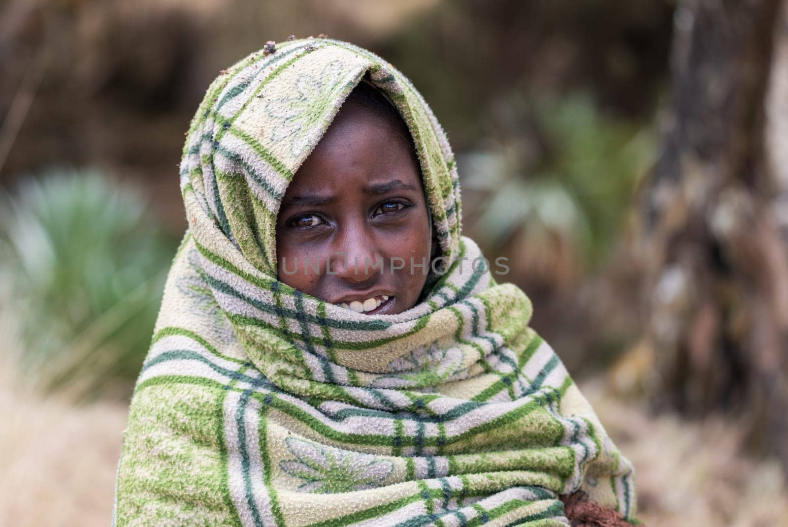 SIMIEN MOUNTAIN, ETHIOPIA, APRIL 25.2019, Little Ethiopian shepherdess girl veiled in a blanket in cold morning. Simien Mountains, Ethiopia, April 25. 2019