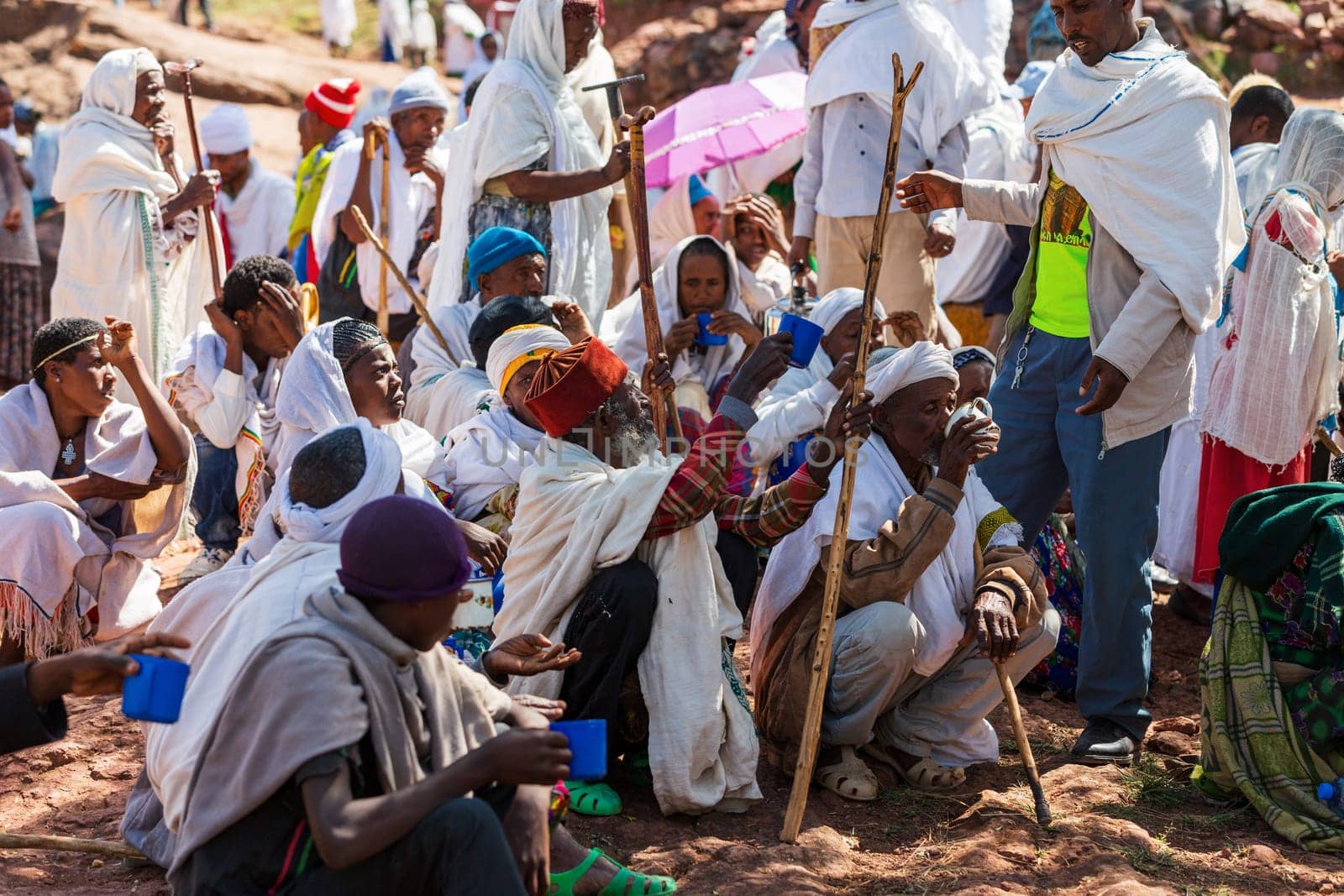 Lalibela, Ethiopia - May 1, 2019: Orthodox Ethiopians unwind at St. George Church after Mass. A serene moment capturing faith and cultural richness.
