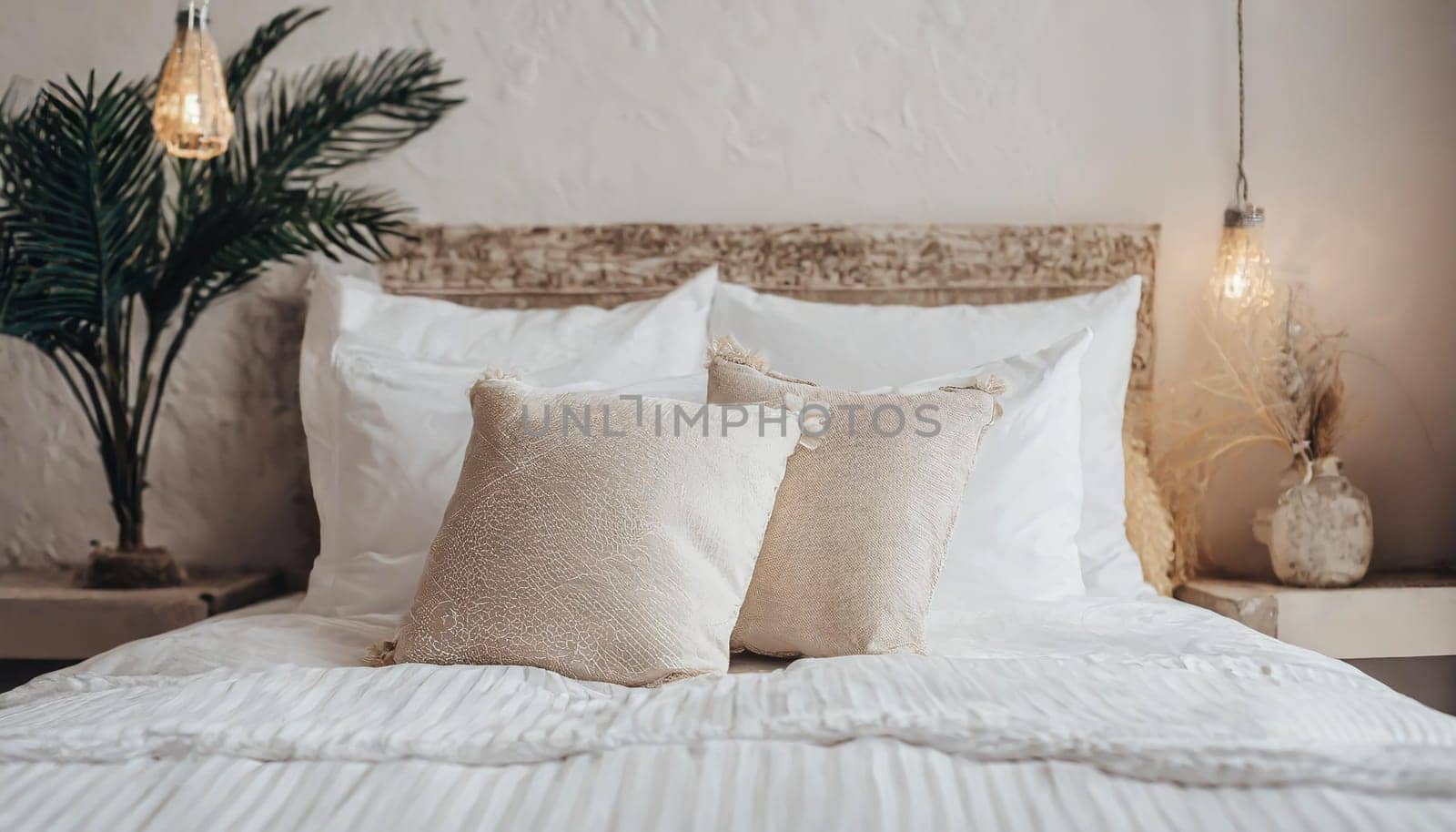 Clean Bedding sheets and pillow on natural wall room background. White bedding and pillow in hotel room. White pillows on empty bed.